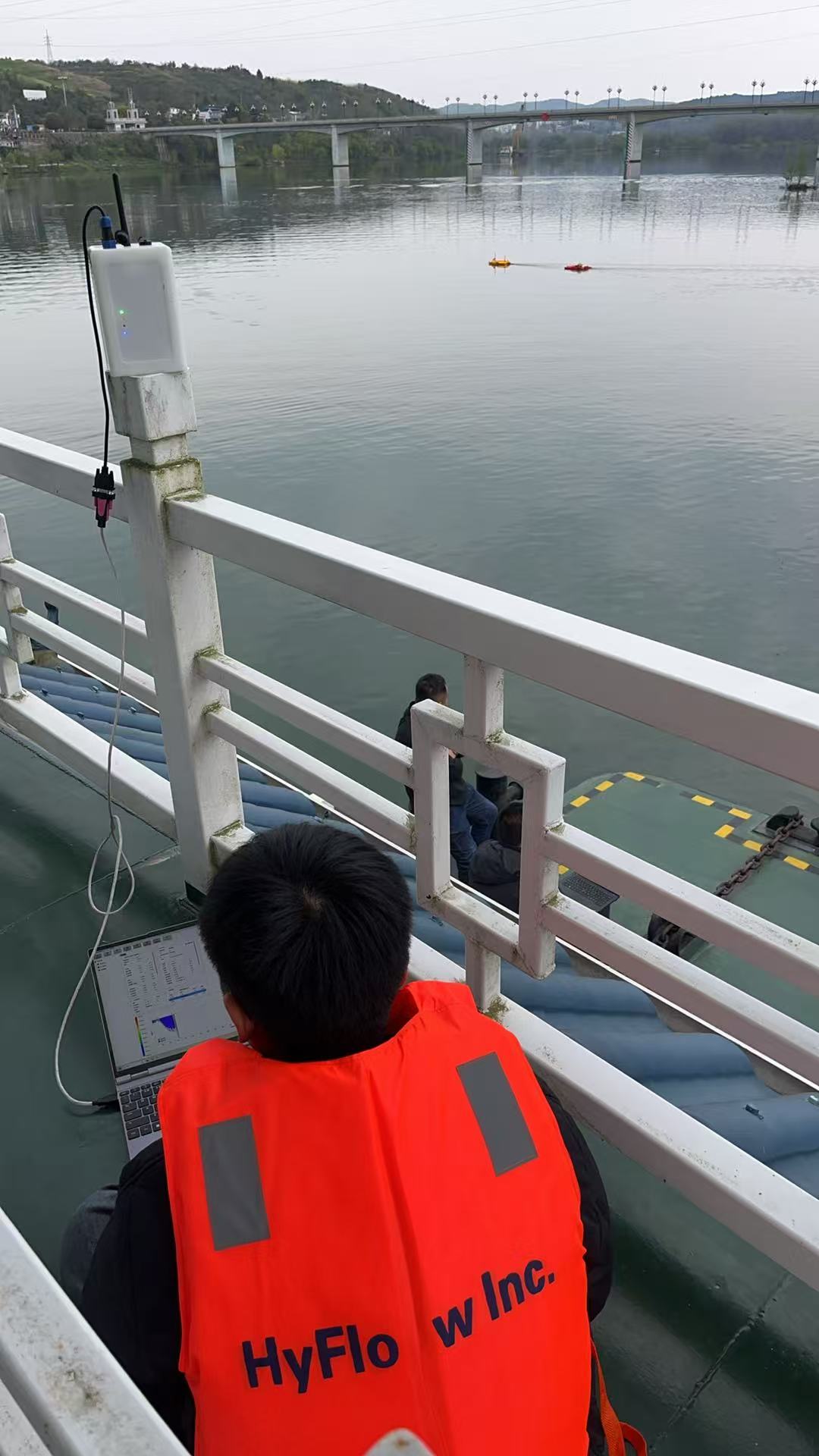 HyFlow engineer monitoring a bridge-based river discharge measurement with remote-controlled ADCP